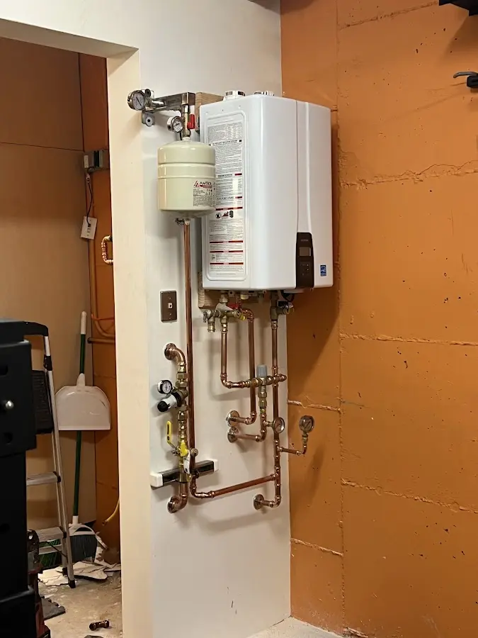 Plumbing technician inspecting water heater connections in Clark